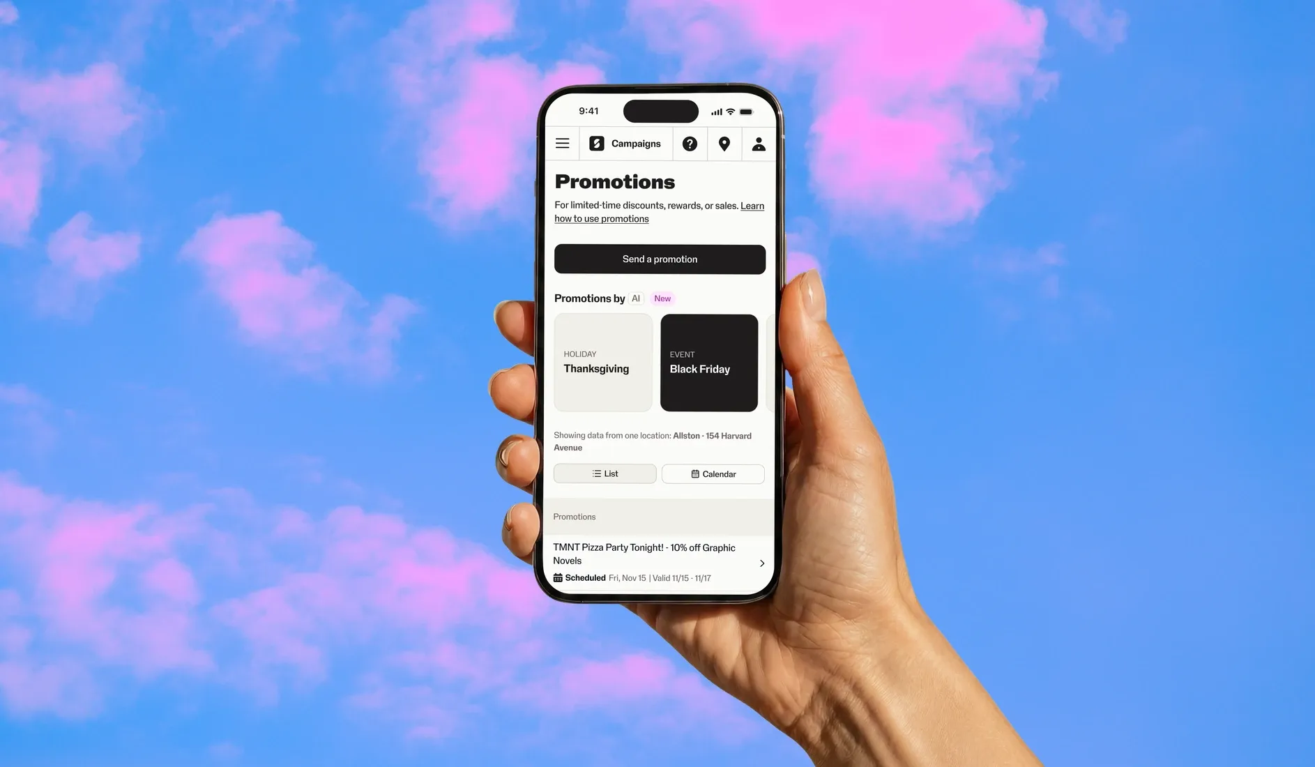 A hand holds a phone showing SumUp's Promotions screen, with new AI-suggested promotions, against a pink and blue sky.